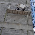 کلایمر ساختمانی نصب شده روی نمای ساختمان برای اجرای عملیات کار در ارتفاع